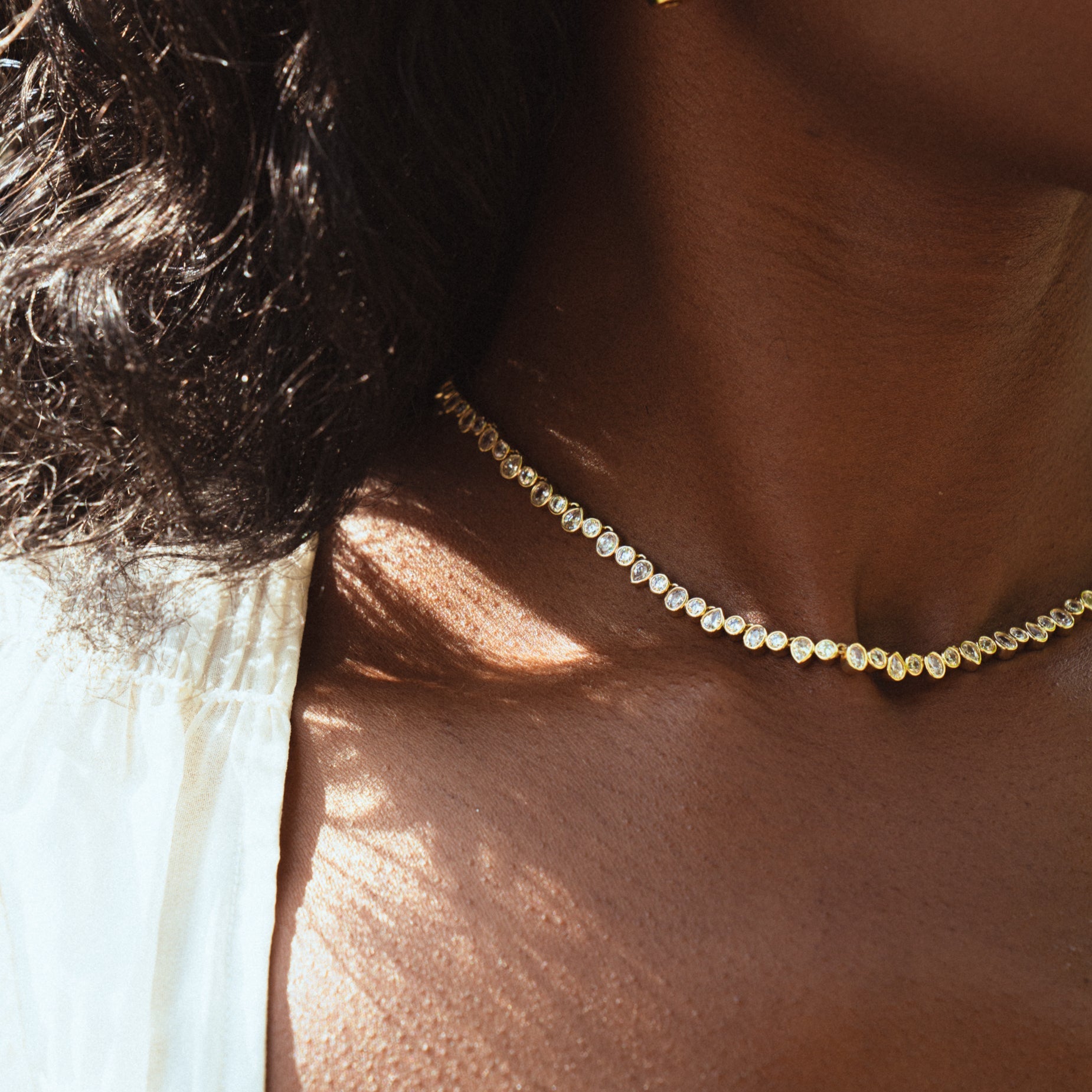 Woman wearing gold and silver tennis necklace