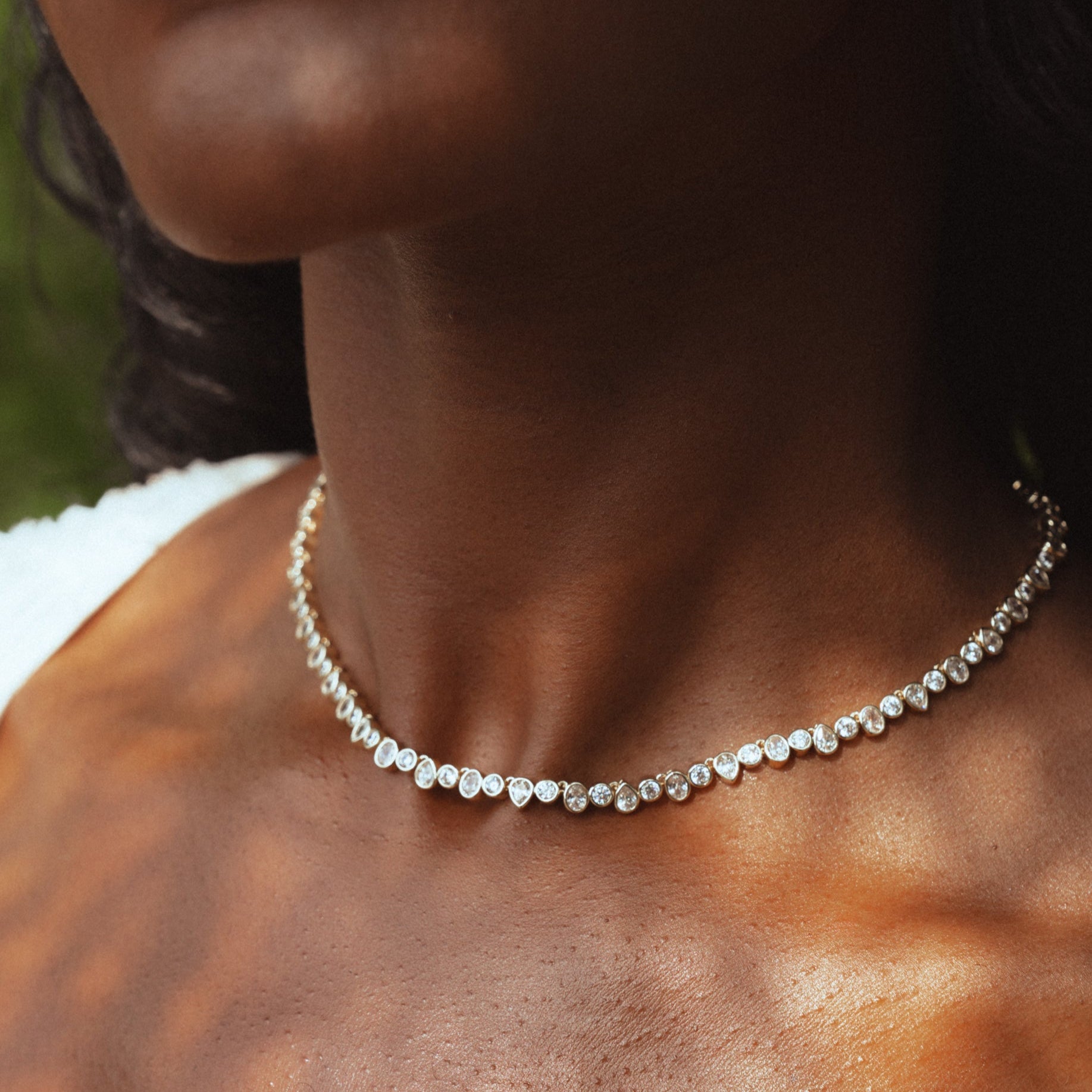 Photo of woman wearing a tennis necklace with gold and silver.